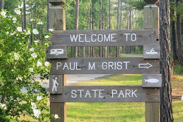 flowers near welcome sign at paul grist state park in selma alabama