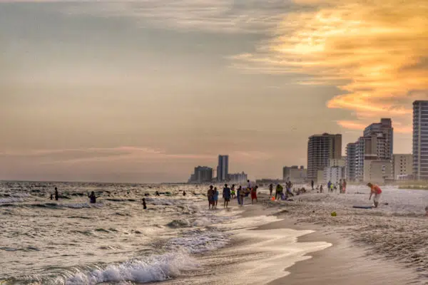 people walking along a gulf coast beach in a state park in alabama