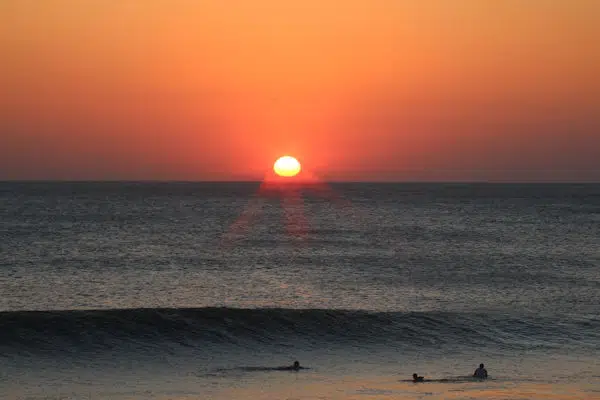 swimmers in the surf at sunset at a state park near hilton head south carolina