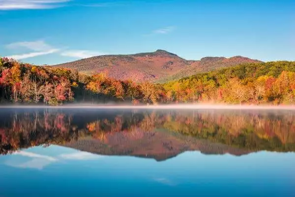 mountain and colorful trees reflected in a lake at a state park near asheville north carolina