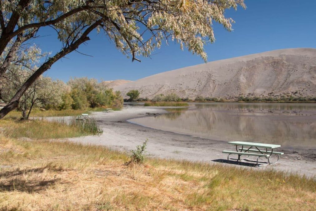 picnic table beside a lake next to a dune in a state park near boise idaho