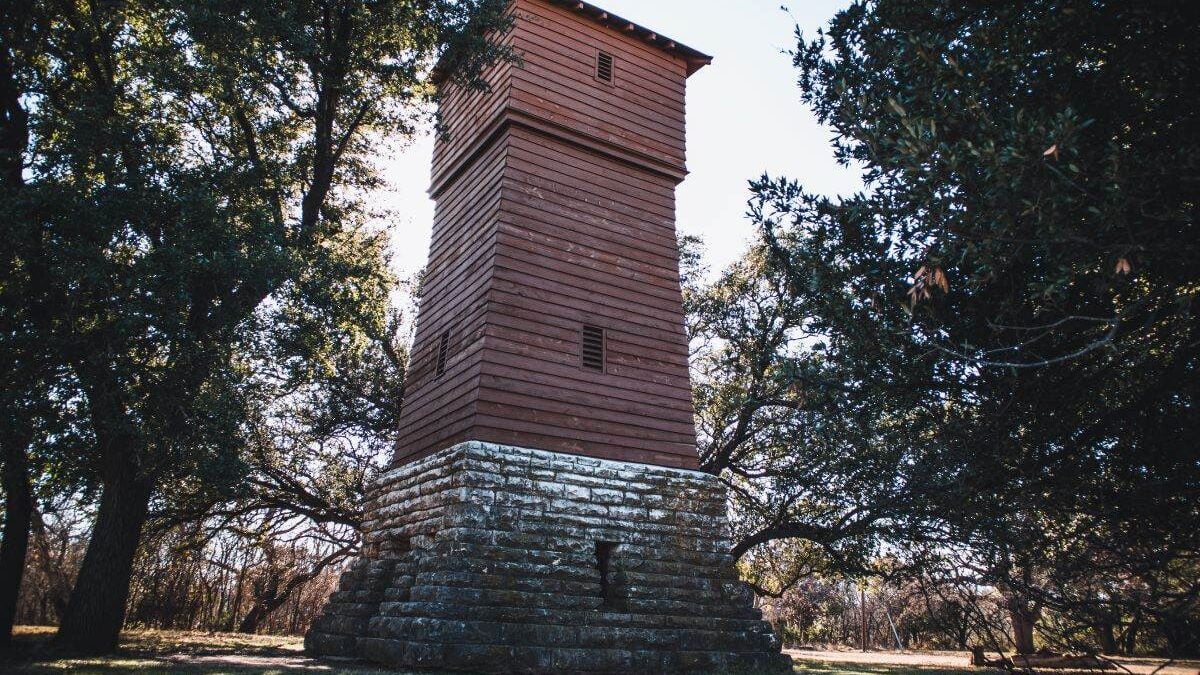 Historic water tower from the 1930s in a wooded area in the Abilene State Park in Texas, USA