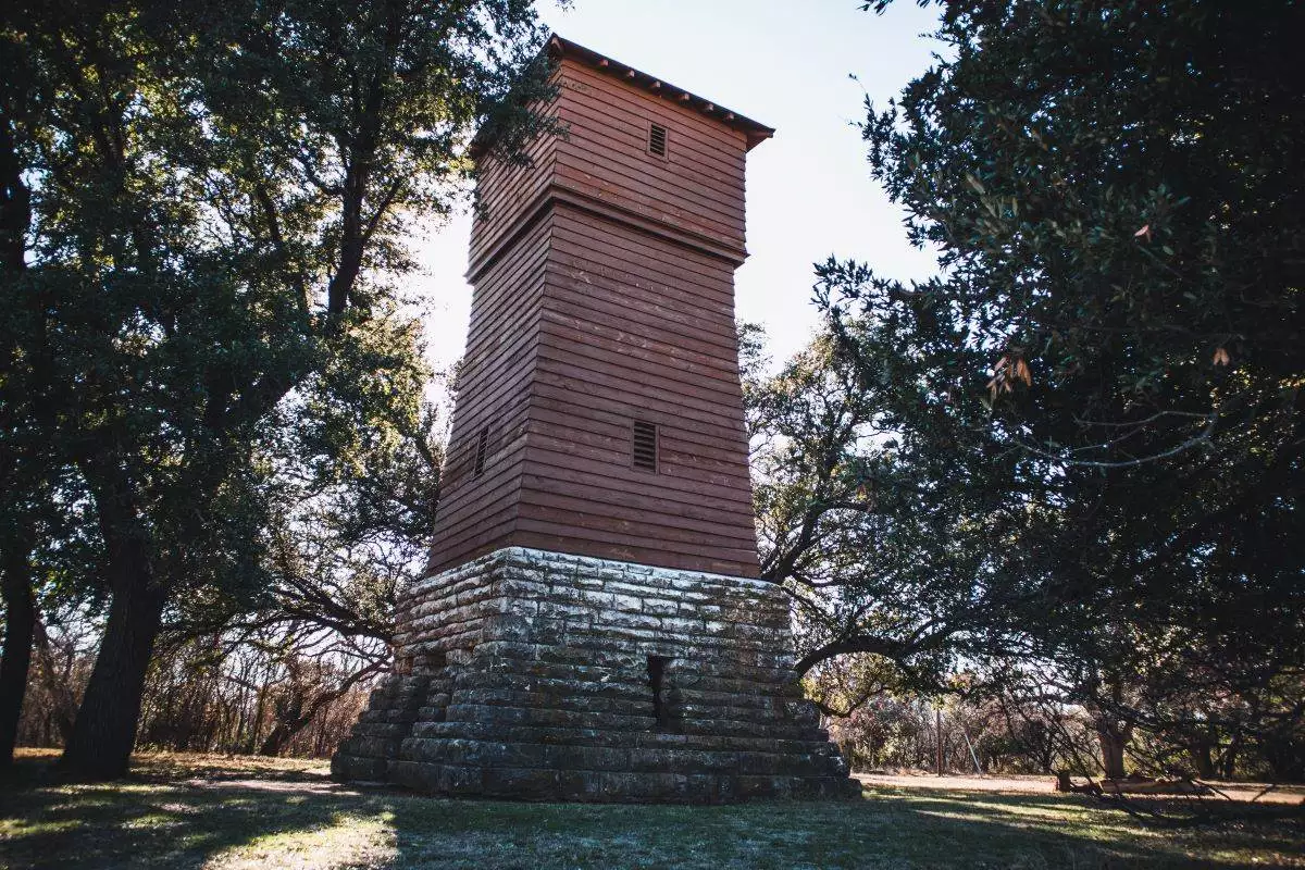 Historic water tower from the 1930s in a wooded area in the Abilene State Park in Texas, USA