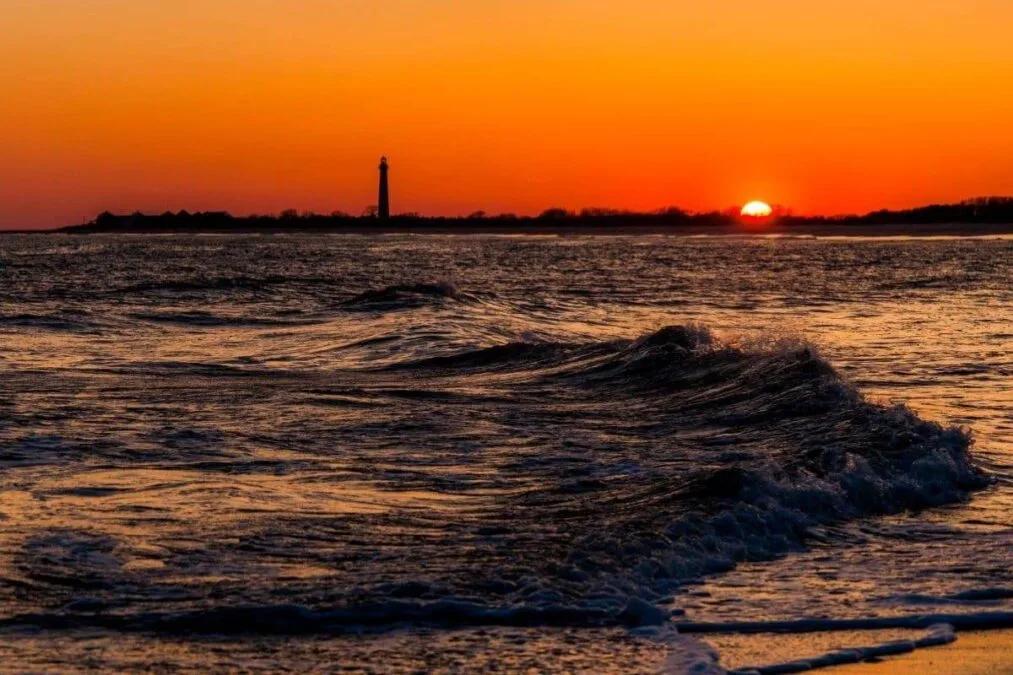 The Cape May Point Lighthouse and waves on the Atlantic at sunset