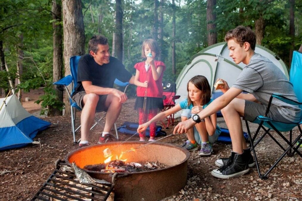 father sitting with his kids in front of a campfire
