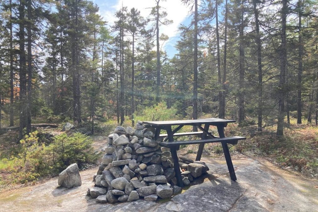 Peaks-Kenny State Park 12 a pile of stones and a picnic table at the top of Birch Mountain Trail at Peaks-Kenny State Park