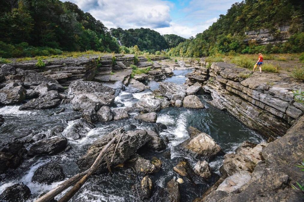 woman hiking along rocky stream in a state park near sevierville tennessee