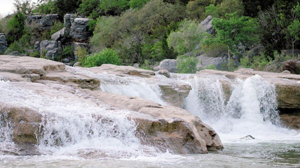 water from the Pedernales River falls over rocks at Pedernales Falls State Park