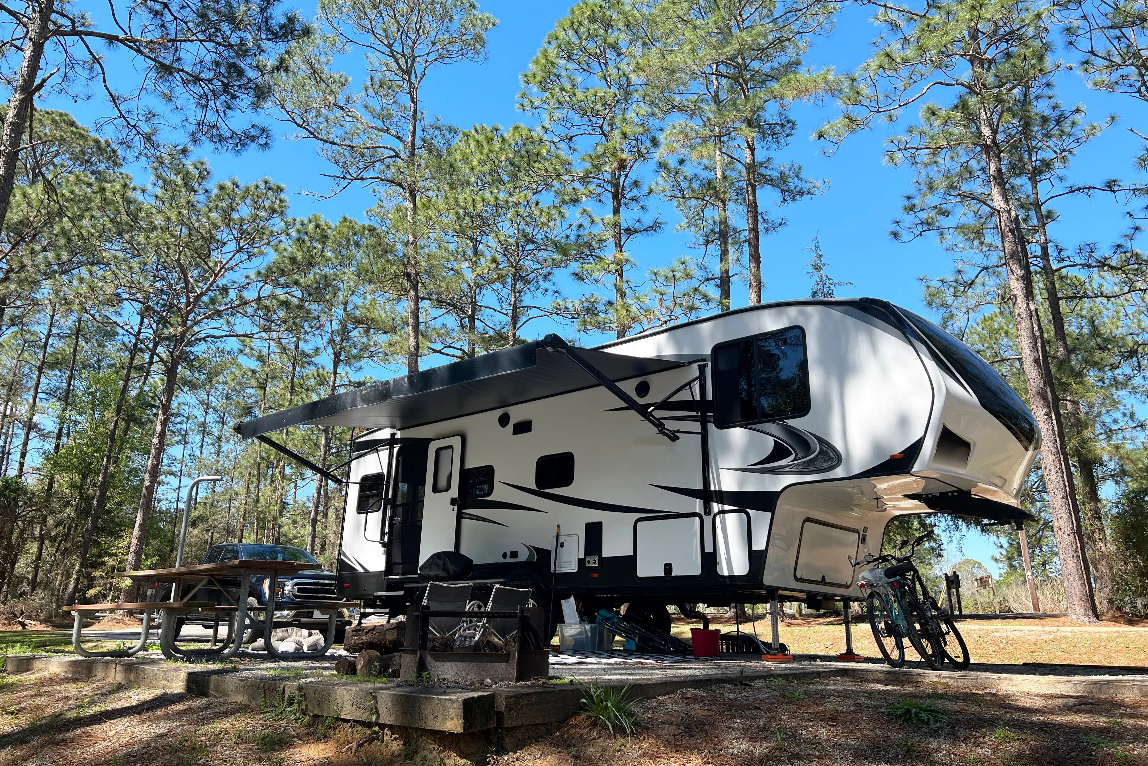 Fifth Wheel RV parked at a state park surrounded by trees