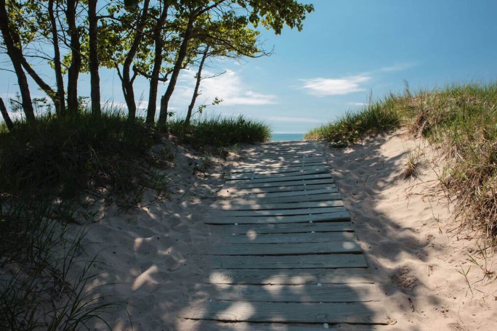 A wooden path leading to a sandy beach in a State Park.