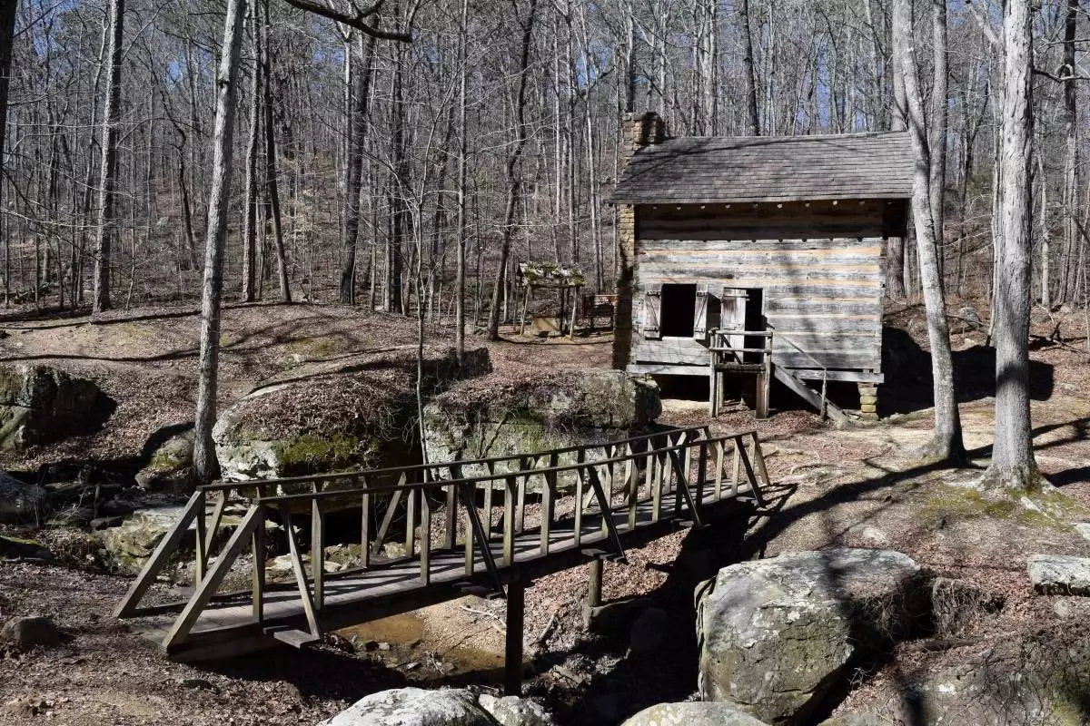 Pioneer cabin across a footbridge at Tishomingo State Park