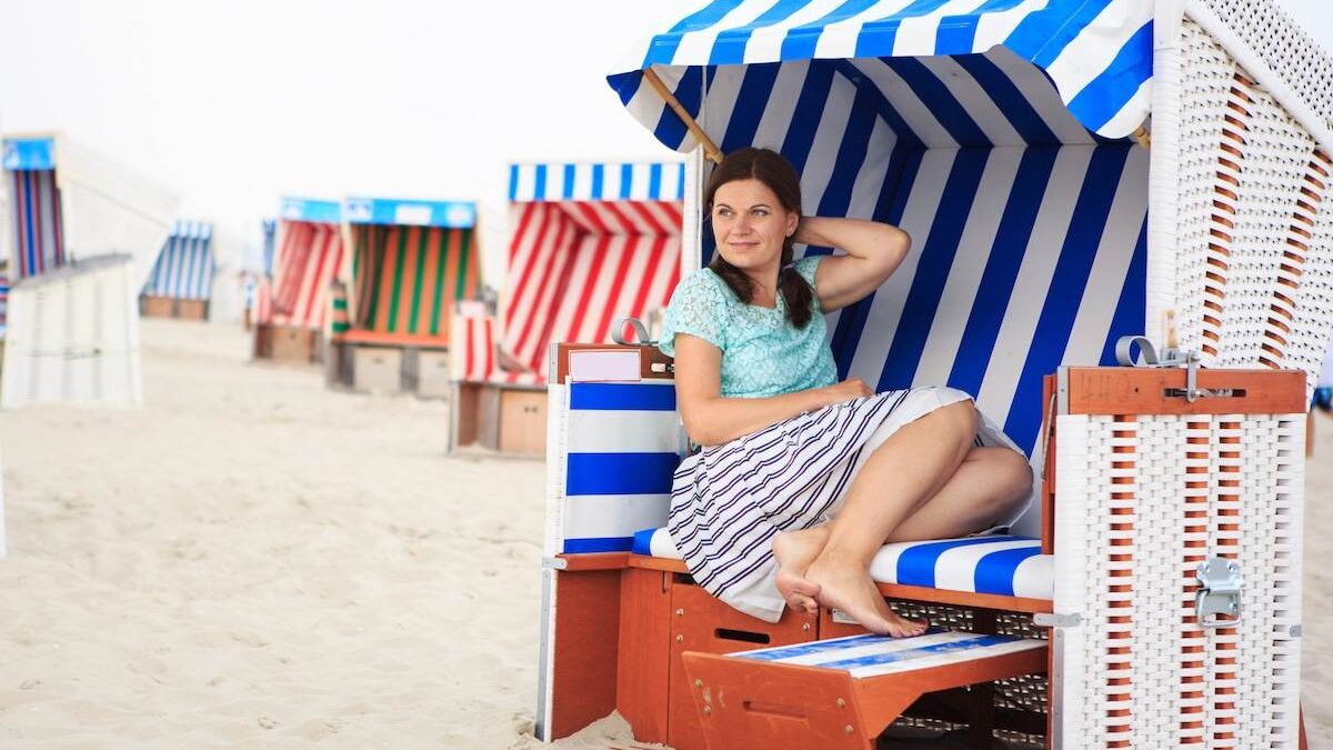 Woman sitting on a beach chair with a canopy