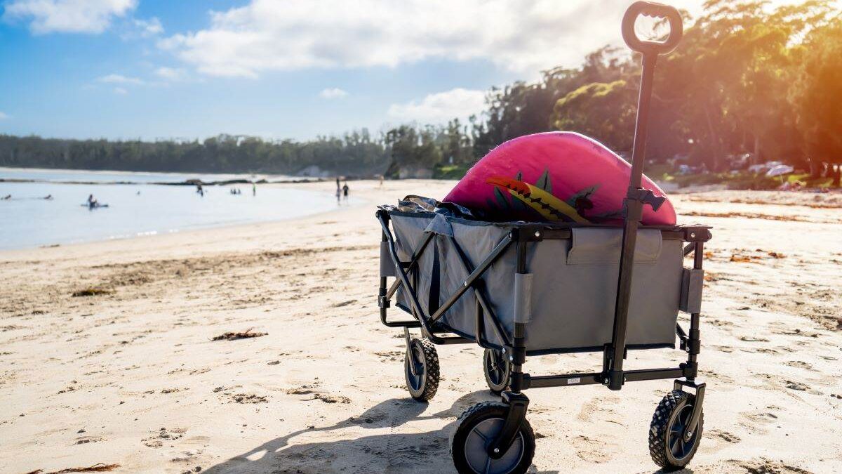 A beach wagon equipped with a beach bag for navigating soft sand.