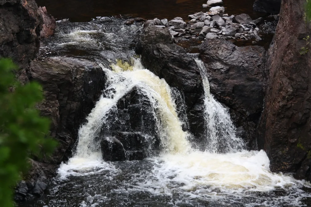 Waterfall rushing over dark basalt rocks at Copper Falls State Park, Wisconsin