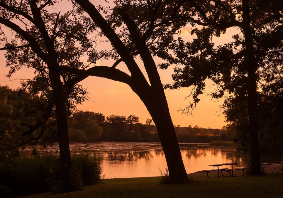 Picnic table on the shore of Lake Louise at sunset in Lake Louise State Park, Minnesota