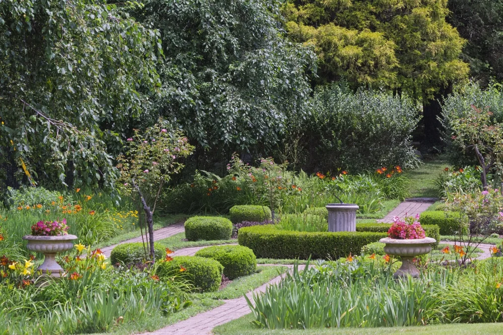 Formal garden with boxwood hedges, stone urns and brick paths at Osbornedale State Park, Connecticut