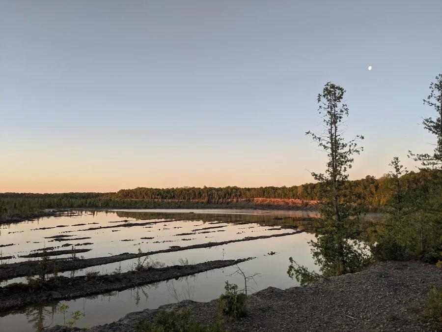 Flooded former quarry pools glowing at dusk with a crescent moon, Rockport State Recreation Area, Michigan