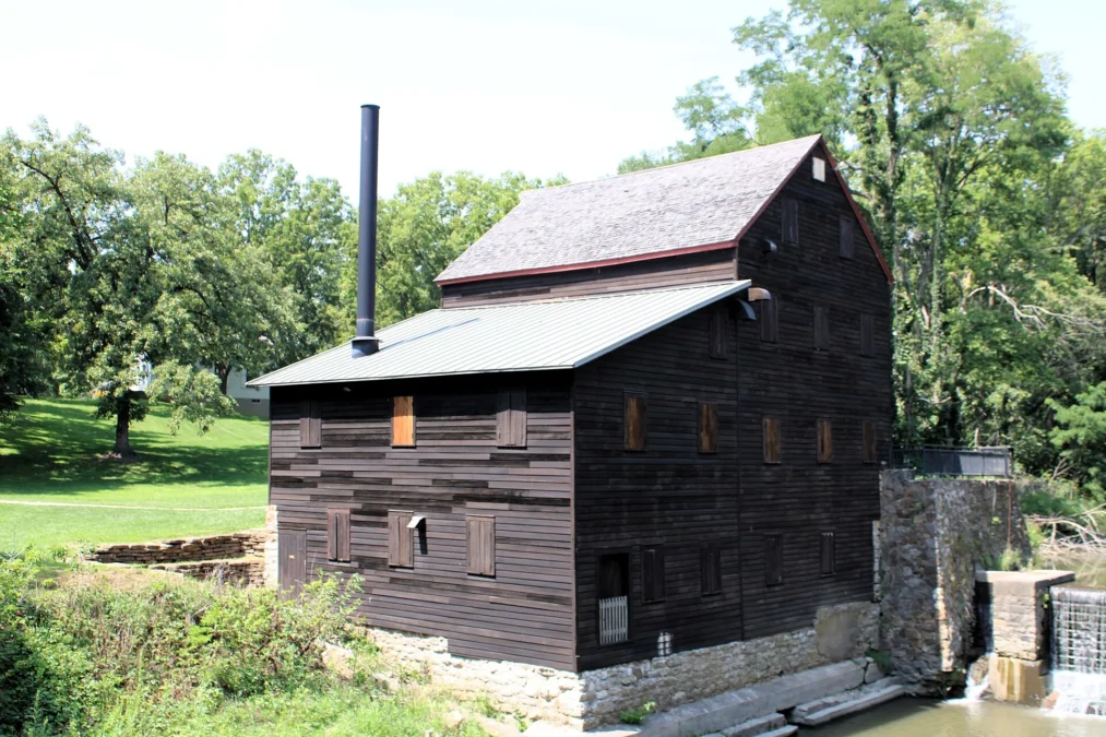 Pine Creek Grist Mill, a dark wooden mill beside a small dam, Wildcat Den State Park, Iowa